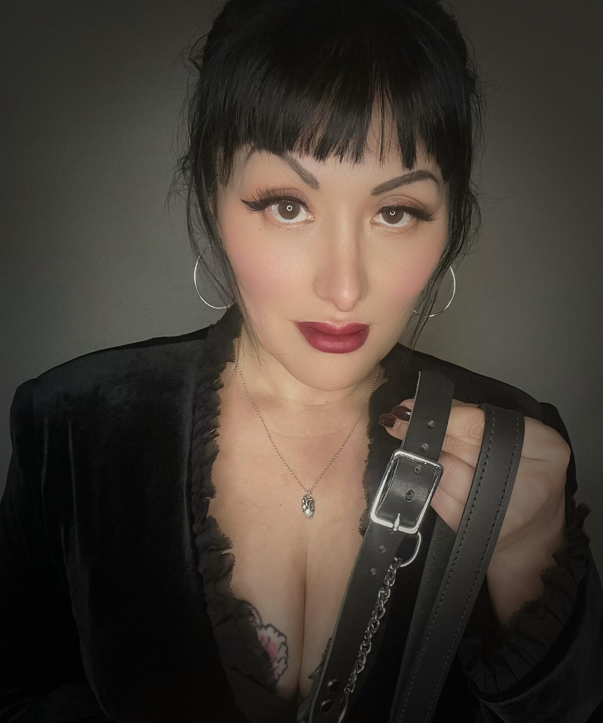 Madame Belladonna, Portland BDSM session in velvet holding leather collar and leash